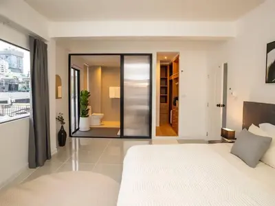 a bedroom with a large white bed and a bathroom at 2-Bedroom Penthouse in the heart of Silom - 4A in Bang Rak