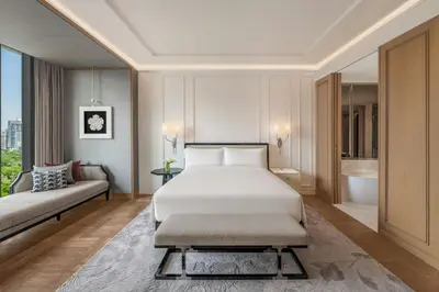 a hotel room with a bed and a couch at The Ritz-Carlton, Bangkok in Bangkok