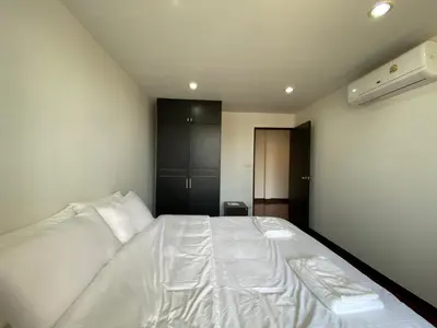 a bedroom with a white bed in a room at Phatana Court in Bangkok