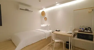 a white bedroom with a bed and a desk at SimpleStay Chatuchak, SureStay Collection by Best Western in Bangkok