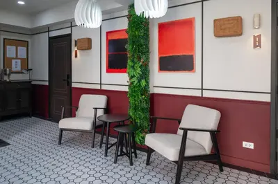 a waiting room with chairs and a green wall at Boutique hotel Axis Bangkok in Bangkok