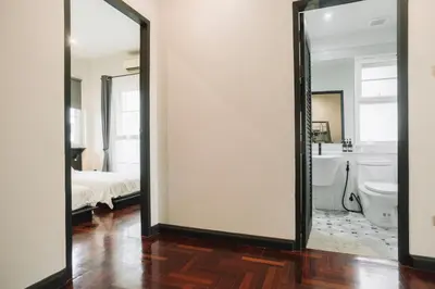 a room with a mirror and a bathroom with a bed at My Sukhumvit Villa in Bangkok