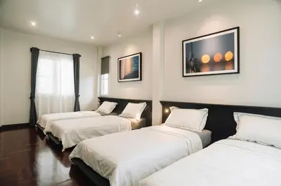 three beds are lined up in a room at My Sukhumvit Villa in Bangkok