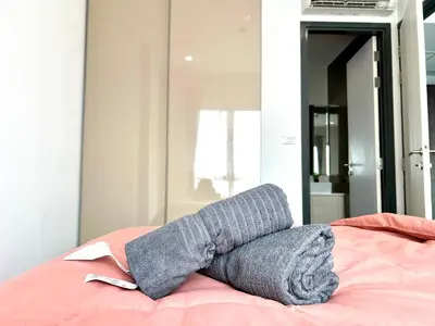 a gray blanket laying on top of a bed at monthly and Annual condo in Bangkok