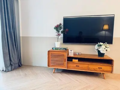 a flat screen tv sitting on top of a wooden entertainment center at Ekkamai\u4e09\u5367\u4e09\u536b\u5c0f\u522b\u5885\u72ec\u680b\u5e26\u505c\u8f66\u4f4d in Bangkok