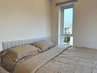 a bed in a white room with a window at hana villa in Bangkok