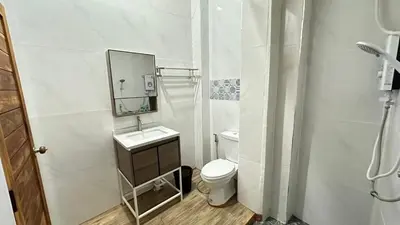 a white bathroom with a toilet and a mirror at Megun 10 L in Bangkok