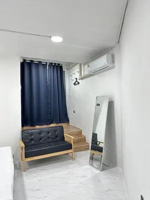 a living room with a couch and a blue curtain at Megun 10 L in Bangkok