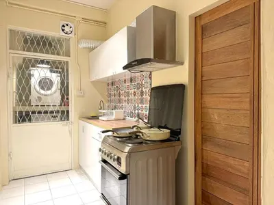 a kitchen with a stove top oven next to a door at Nordic Townhouse FIT Group - 800M MRT Huaykwang in Bangkok