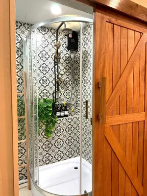 a shower with a glass door next to a bathroom at Nordic Townhouse FIT Group - 800M MRT Huaykwang in Bangkok