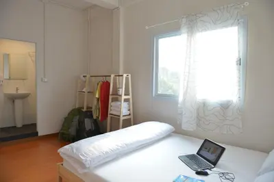 a bedroom with a bed with a laptop on it at PanPan Hostel in Bangkok