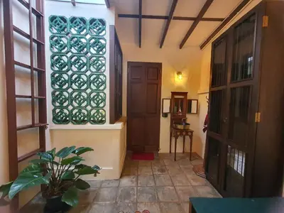 a hallway with a door and a window and a plant at The Courtesan at Yaowarat, townhome 80 Sqm in Samphanthawong