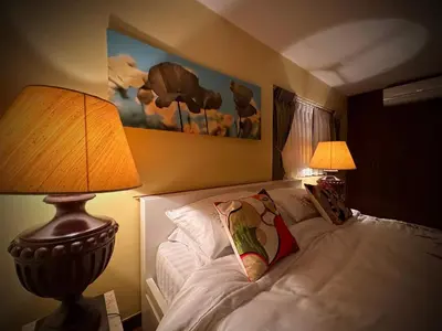 a bedroom with a bed with a lamp and two lamps gmaxwell gmaxwell at Newly-renovated Modern Private Thai Villa with Swimming Pool in Ban Khlong Samrong