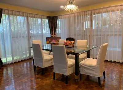 a dining room with a glass table and white chairs at Newly-renovated Modern Private Thai Villa with Swimming Pool in Ban Khlong Samrong