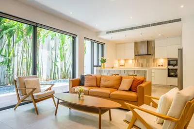 a living room with a couch and a table at Designer Pool Villa in Ekkamai in Bangkok