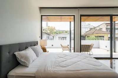 a bedroom with a large bed and a large window at Designer Pool Villa in Ekkamai in Bangkok