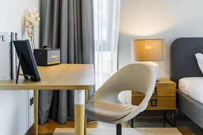 a desk with a white chair next to a bedroom at Designer Pool Villa in Ekkamai in Bangkok