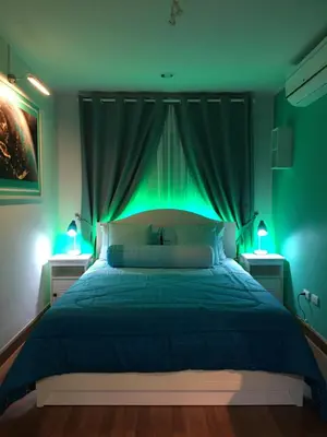 a bedroom with a bed with green lighting at White Turquoise -2 Bedrooms Apartment- in Bangkok