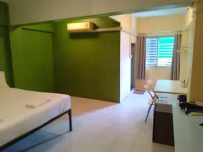 a room with a bed and a green wall at z GO INN The Grand Palace Bangkok-Mrt Samyot Station in Bangkok