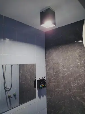 a bathroom with a shower with a mirror at ONEWAY Guest House BKK in Bangkok