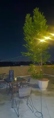 a table and chairs and a tree on a patio at ONEWAY Guest House BKK in Bangkok