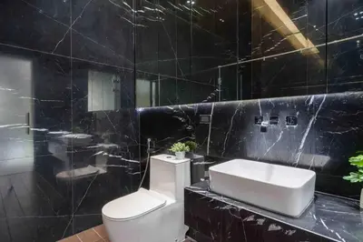 a black tiled bathroom with a toilet and a sink at The Oasis Tranquil Escape in Bangkok