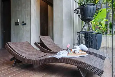 a wicker chair on a patio with a table at The Oasis Tranquil Escape in Bangkok