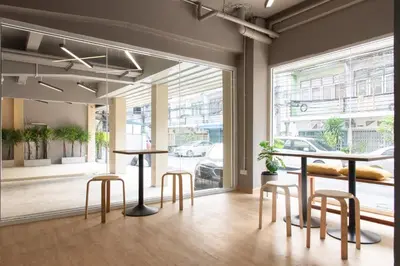 a room with two tables and stools in front of a window at Samyan Story Boutique Hotel in Bangkok