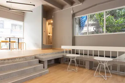 a room with stairs and a table and two stools at Samyan Story Boutique Hotel in Bangkok