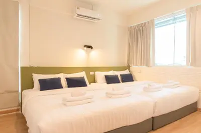 a bedroom with a large white bed with towels on it at Samyan Story Boutique Hotel in Bangkok