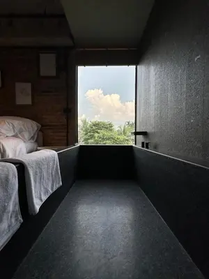 a bedroom with a bed and a large window at Cataleya Estate Boutique Bed & Breakfast in Bangkok