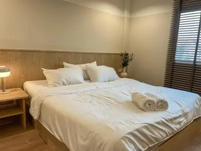 a large white bed with two towels on it at Vanilla house in Nonthaburi