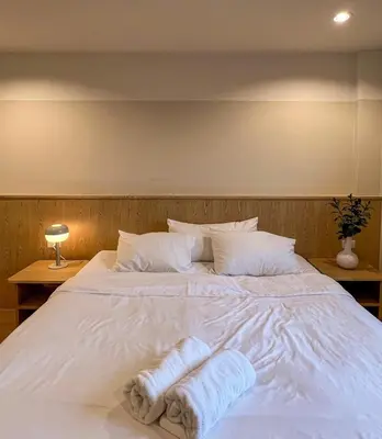 a large white bed with two towels on it at Vanilla house in Nonthaburi