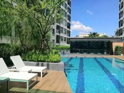 a swimming pool with two white chairs next to a building at \u7d20\u5764\u903850\u5df7\u4e00\u623f\u4e00\u5385\u514d\u8d39Wi-Fi\u7b80\u5355\u5b89\u9759\u53ef\u505a\u996d\u4ea4\u901a\u65b9\u4fbf in Amphoe Phra Khanong