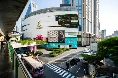 a bus is parked in front of a building at Elite Hotel Asok Sukhumvit 20 in Bangkok