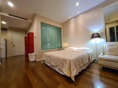 a bedroom with a bed and a chair and a window at The Address Chidlom 41sqm Studio 650m BTS Chit Lom in Bangkok