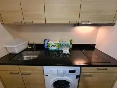 a kitchen counter with a sink and a washing machine at The Address Chidlom 41sqm Studio 650m BTS Chit Lom in Bangkok