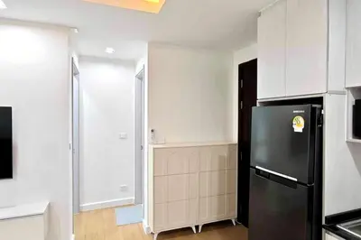 a kitchen with a black refrigerator and white cabinets at 1BHK Apt High floor in Thonglor WiFi-Pool-Fitness in Bangkok