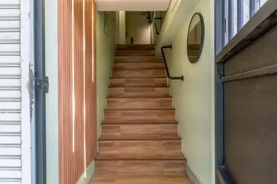 a staircase in a house with wooden floors at Cozy Corner Bangpho in Bang Su