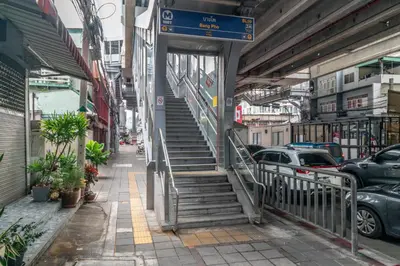 a stairway leading up to a building on a city street at Cozy Corner Bangpho in Bang Su