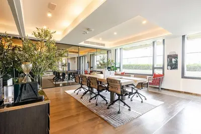 an office space with a table and chairs and windows at Pet Friendly Modern Nest Asoke in Bangkok