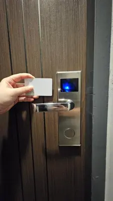 a person unlocking a door with a cell phone at Smile Home โรงแรม ห้องพัก รายวัน รายเดือน in Ban Zong Katiam