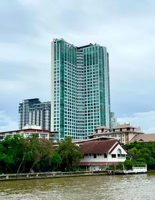 a tall building next to a river with buildings at Riverside room with best view in heart of BKK in Godown
