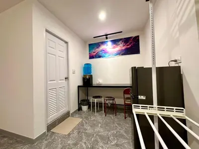 a room with a refrigerator and a table and chairs at The White Den Chatuchak in Bang O