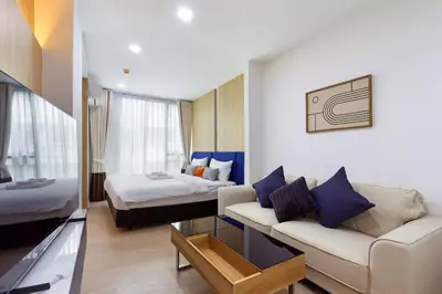 a hotel room with a couch and a bed at Aquila Hotel Bangkok in Bangkok