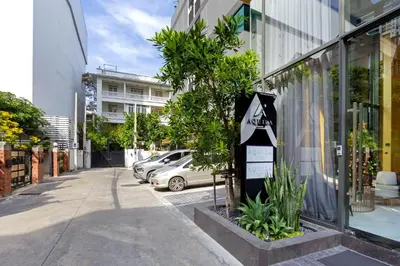 a tree in a planter in front of a building at Aquila Hotel Bangkok in Bangkok