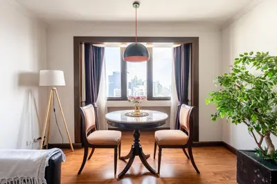 a dining room with a table and chairs and a window at Artichoke Suite Sukhumvit, Nana BTS in Bangkok