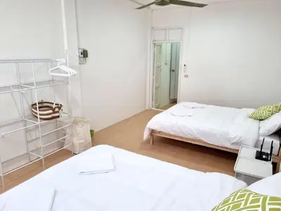 two beds in a room with white walls at Haus Sathorn Pier 2 Cozy Bedroom City Center in Bangkok