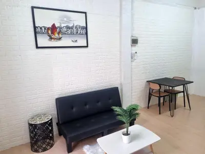 a living room with a black couch and a table at Haus Sathorn Pier 2 Cozy Bedroom City Center in Bangkok