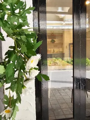 a door with white flowers in front of a building at Seen Hostel Bangkok The Riverwalk in Bangkok